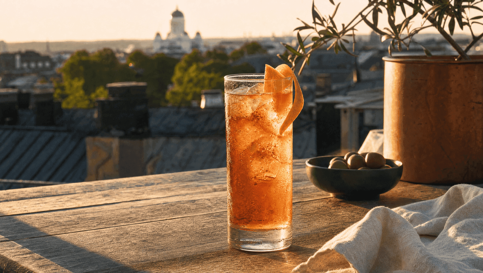 Alkoholiton kuparinen drinkki kattoterassilla auringonlaskussa